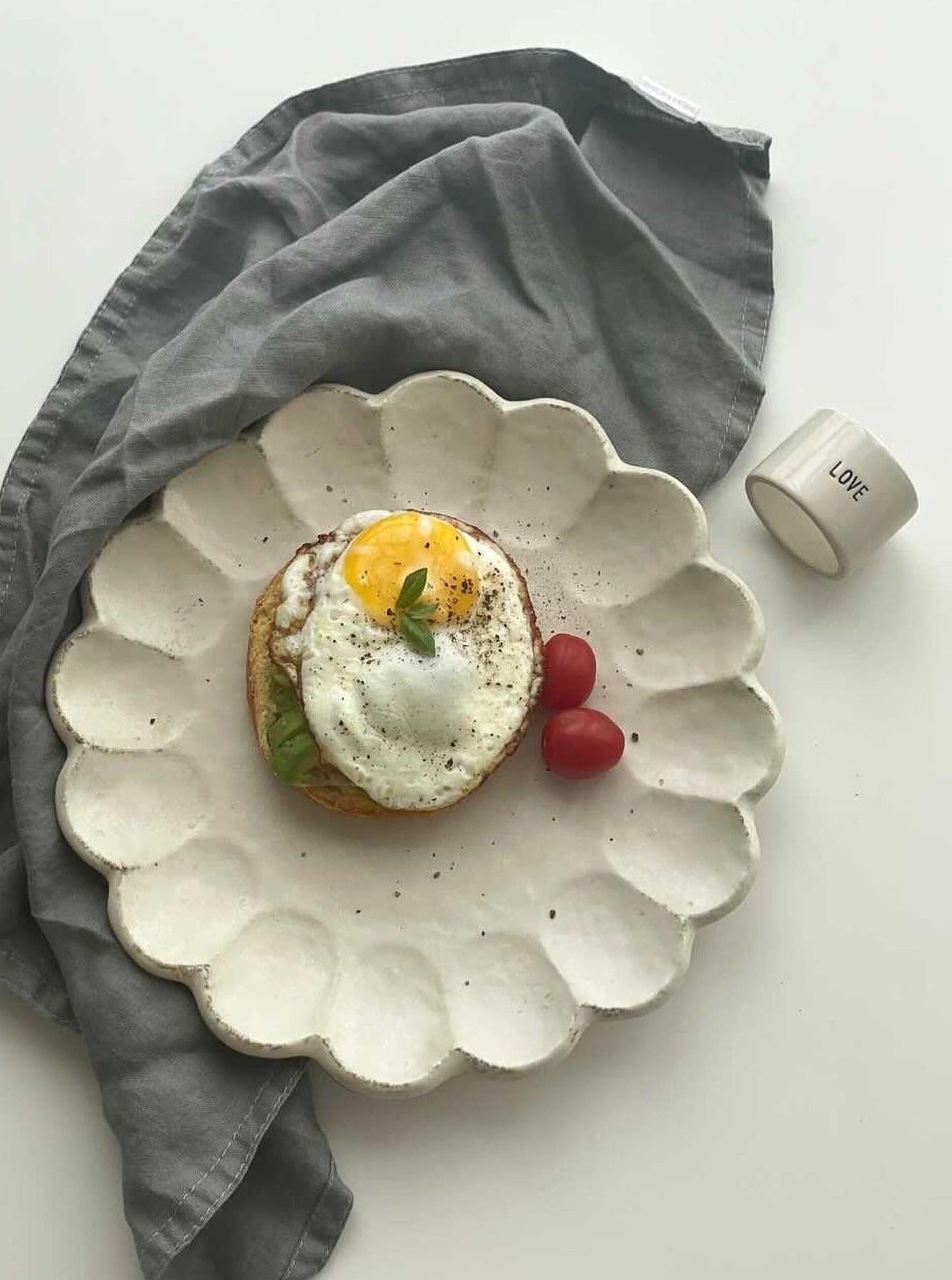 Elegant Rinka Plate 24cm with Fried Egg, Avocado, and Cherry Tomatoes on Gray Cloth – Handcrafted Japanese Porcelain Dish.