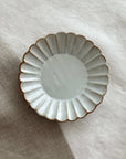 Marumitsu Barbarie plate with petal-like rim on linen background, showcasing elegant design and pottery craftsmanship.
