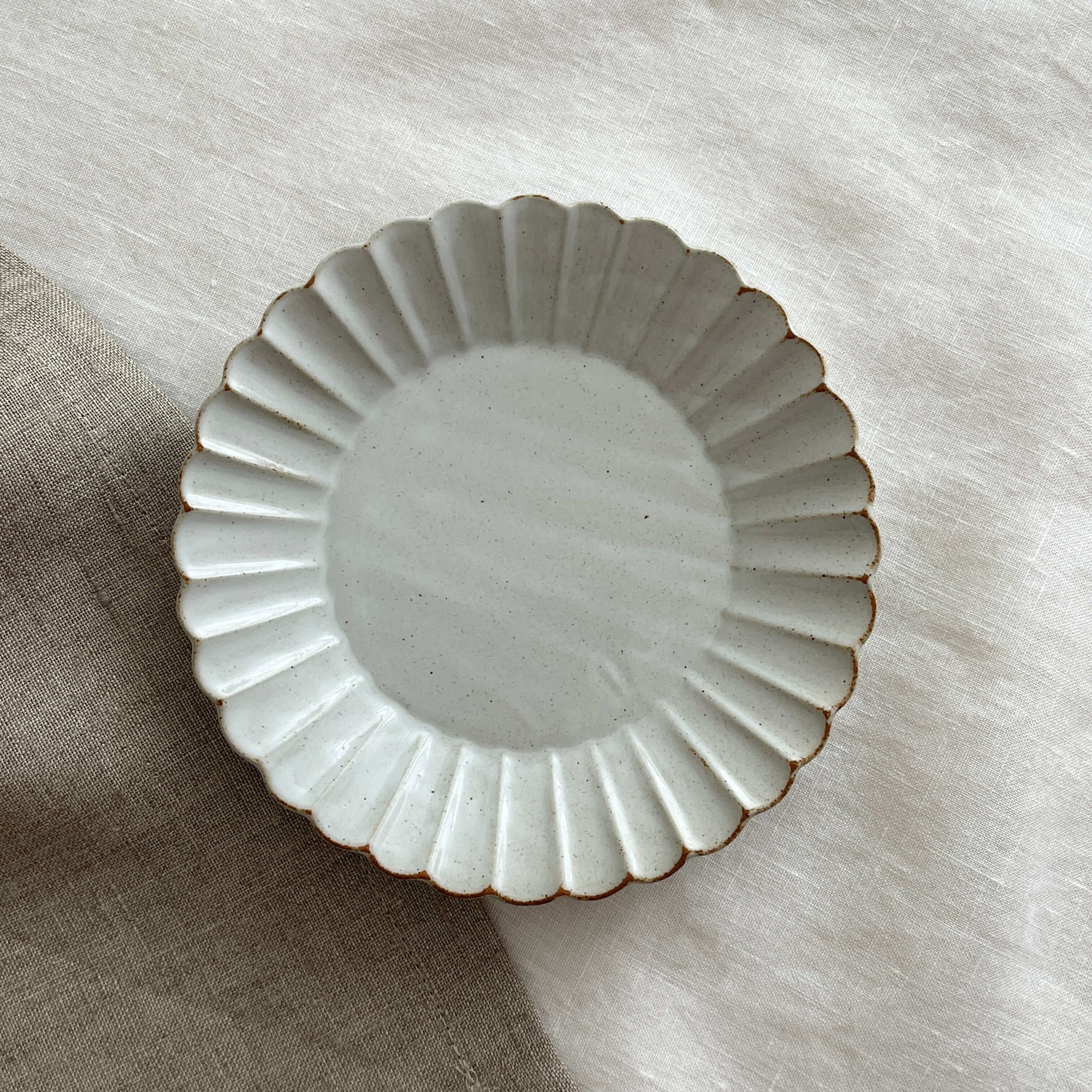 Marumitsu Barbarie plate with petal-like rim design on linen surface, ideal for enhancing meal presentation.