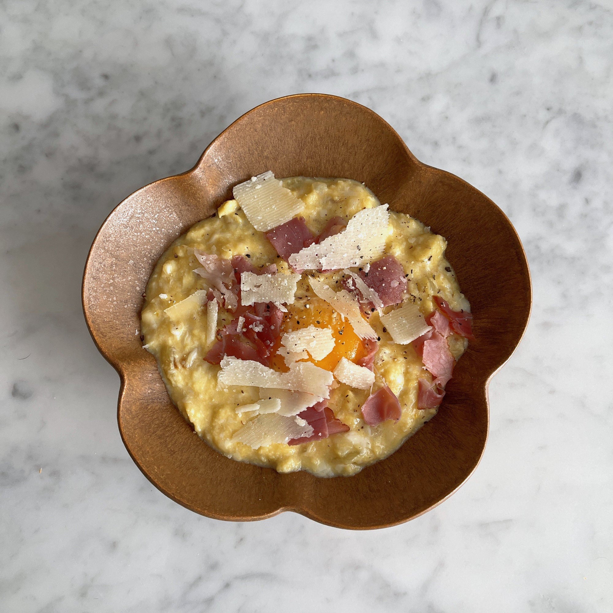 Elegant UME bowl with creamy risotto, topped with shaved cheese and ham, enhancing any table setting.