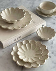 Rinka Bundle 1 Japanese porcelain dishes with elegant flower petal design on a marble surface, showcasing craftsmanship and style.