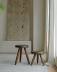 Meribel Stools in teak wood, inspired by Alpine architecture, showcased in a minimalist room with natural light and textured decor.