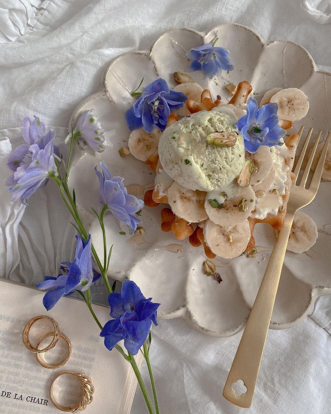 Elegant Rinka Plate with dessert, blue flowers, and gold fork on a table, showcasing Japanese craftsmanship and aesthetic beauty.