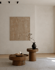 Elegant living room with a wooden coffee table set, featuring natural log textures and a minimalist design against a light wall background.
