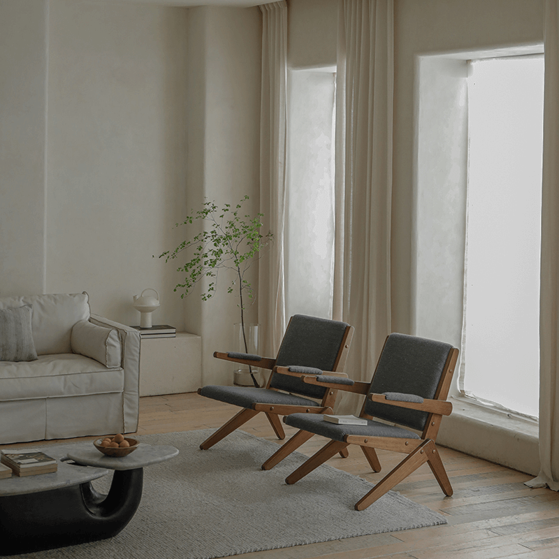 Modern living room with two teak wood Scissors Chairs showcasing sleek design, comfort, and style.