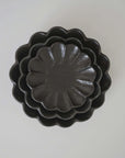 Stacked black Rinka plates showcasing elegant scalloped design, handcrafted from porcelain by Kaneko Kohyo, Japan.