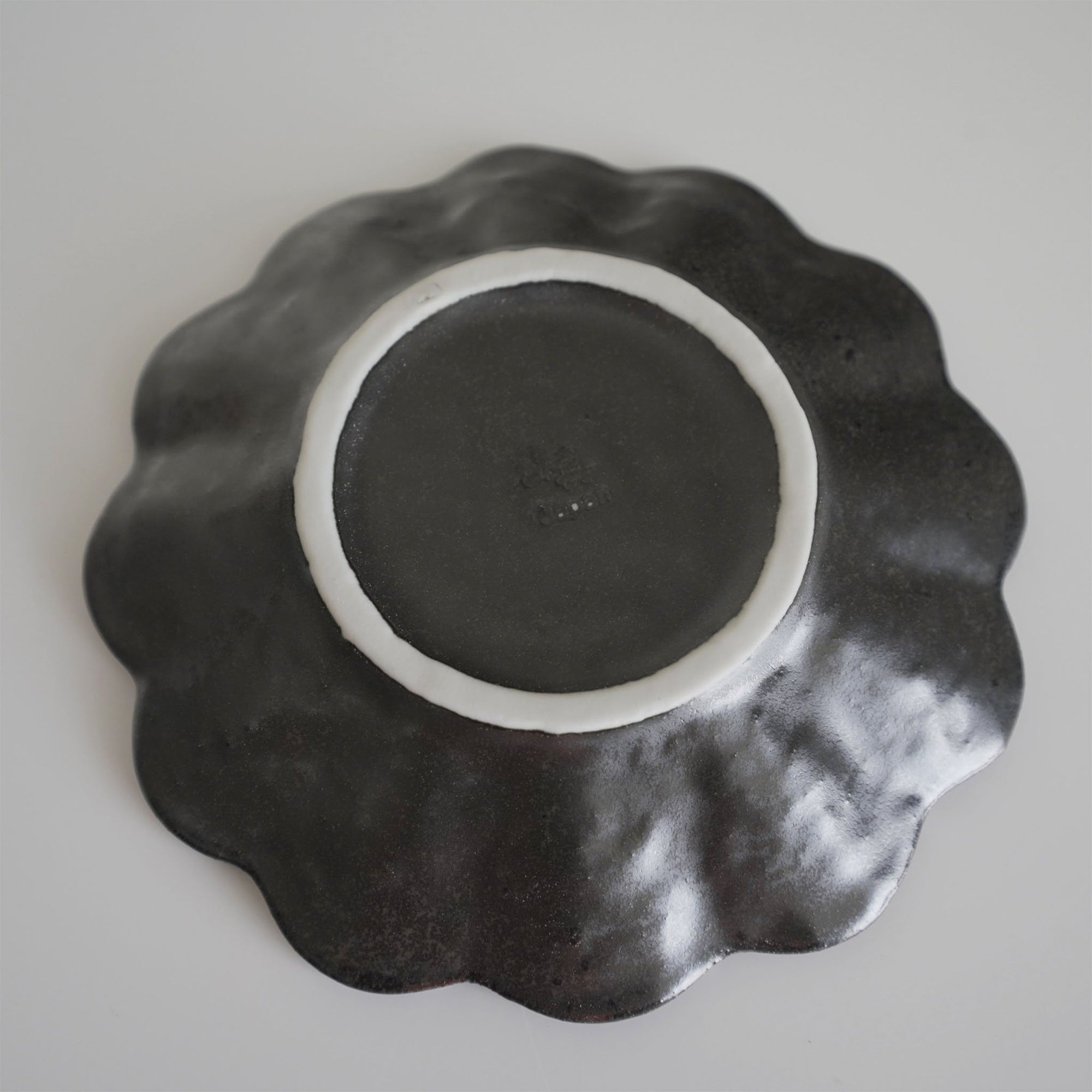 Bottom view of a 14cm Rinka porcelain plate showcasing its wavy design and craftsmanship from the Rinka Collection.