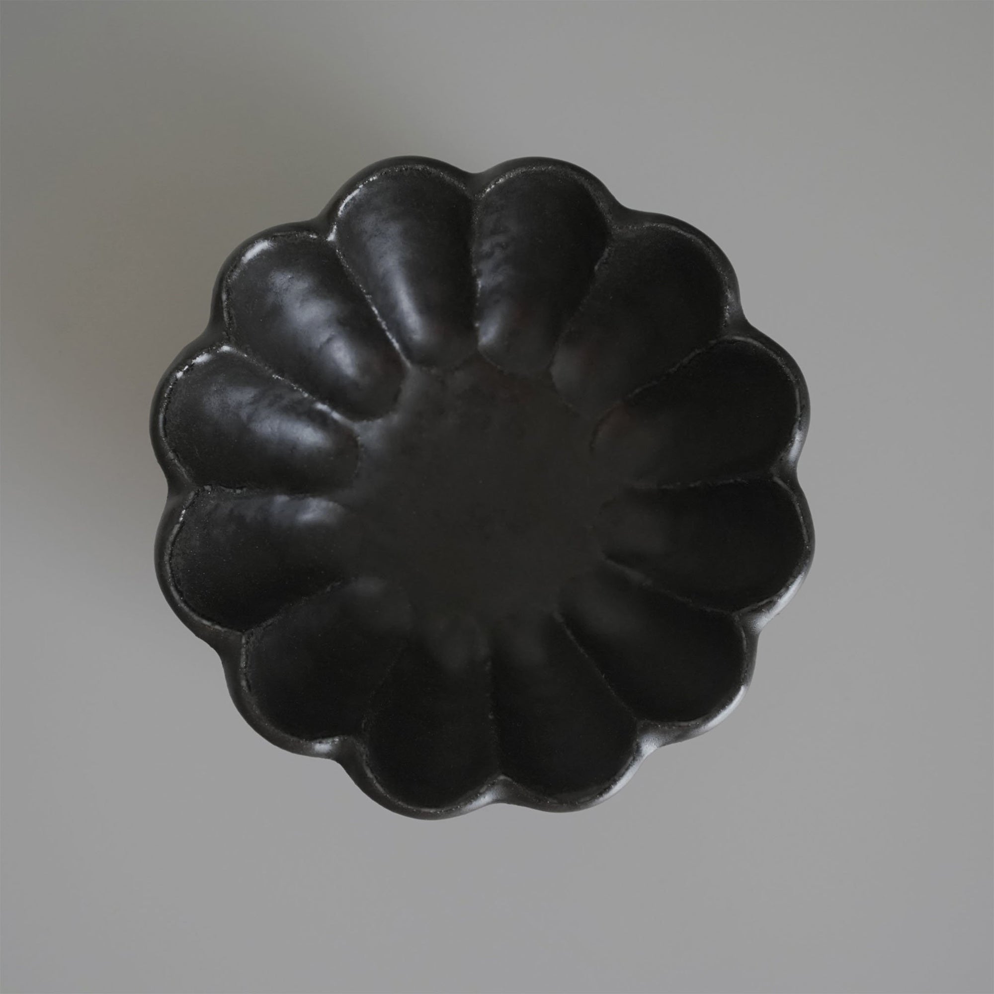 Black Rinka Bowl 12cm in flower shape from Kaneko Kohyo's porcelain collection, perfect for enhancing table settings.