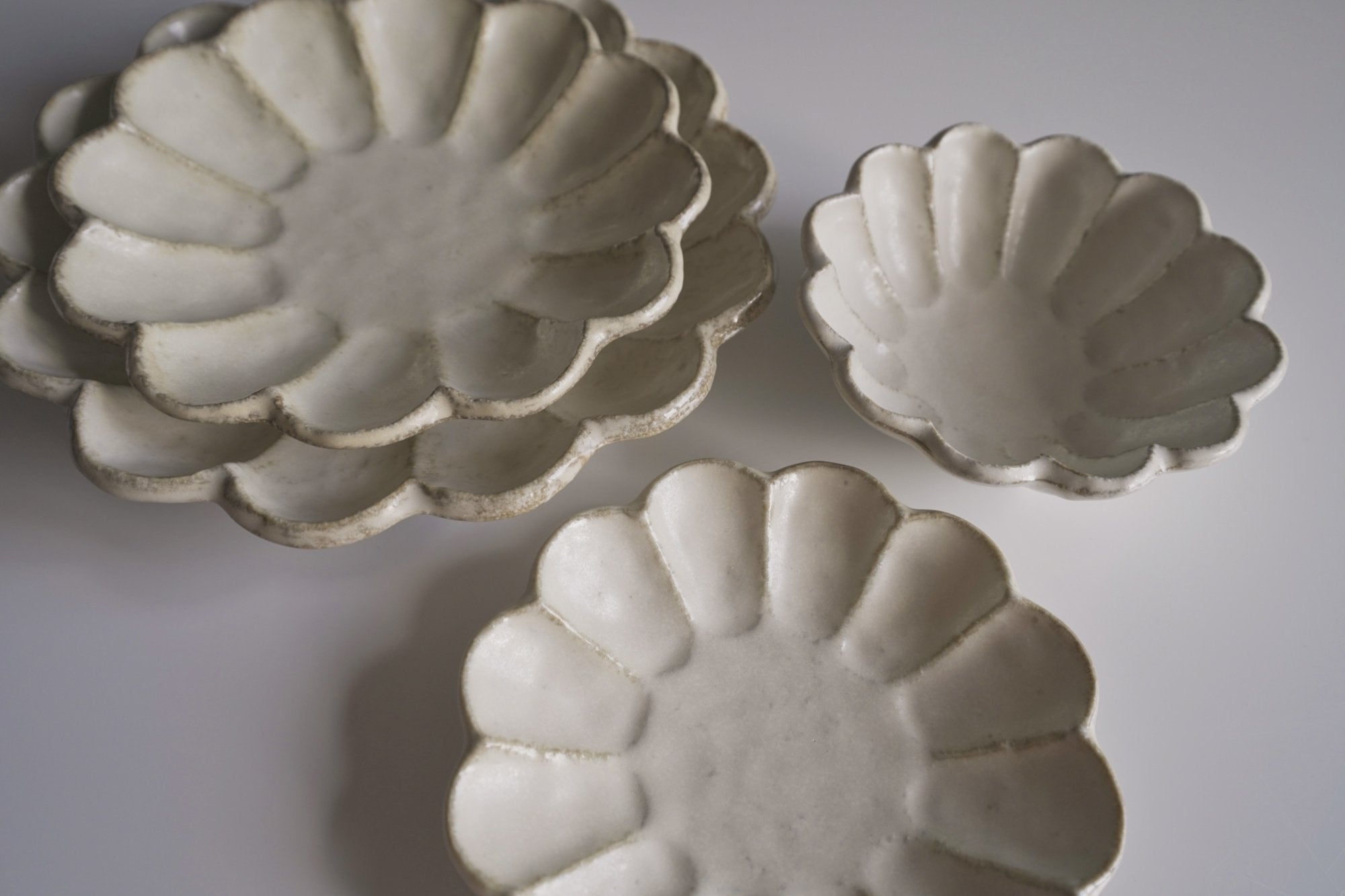 Rinka Collection porcelain plates handcrafted in Japan, showcasing elegant scalloped design, perfect for enhancing table aesthetics.