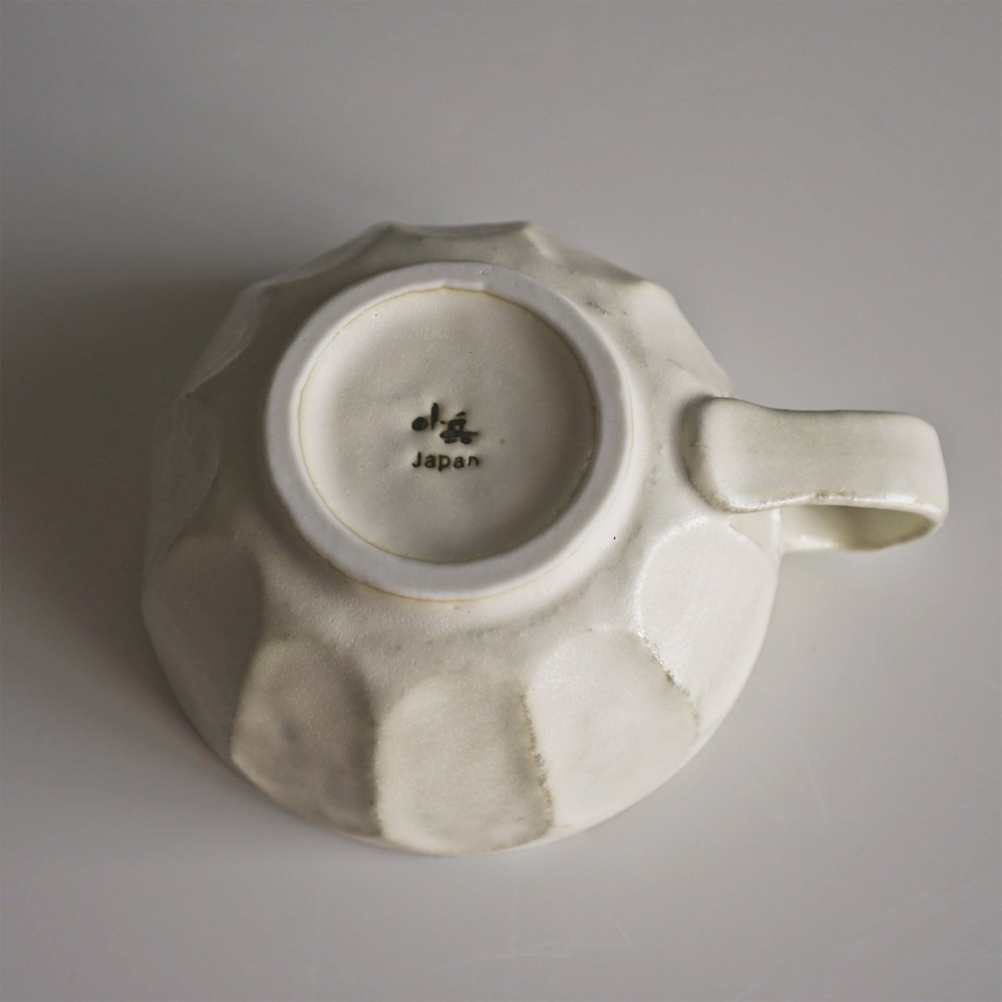 Bottom view of handcrafted Rinka Soup Cup by Kaneko Kohyo, showcasing delicate porcelain and unique flower shape design.