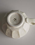 Bottom view of handcrafted Rinka Soup Cup by Kaneko Kohyo, showcasing delicate porcelain and unique flower shape design.