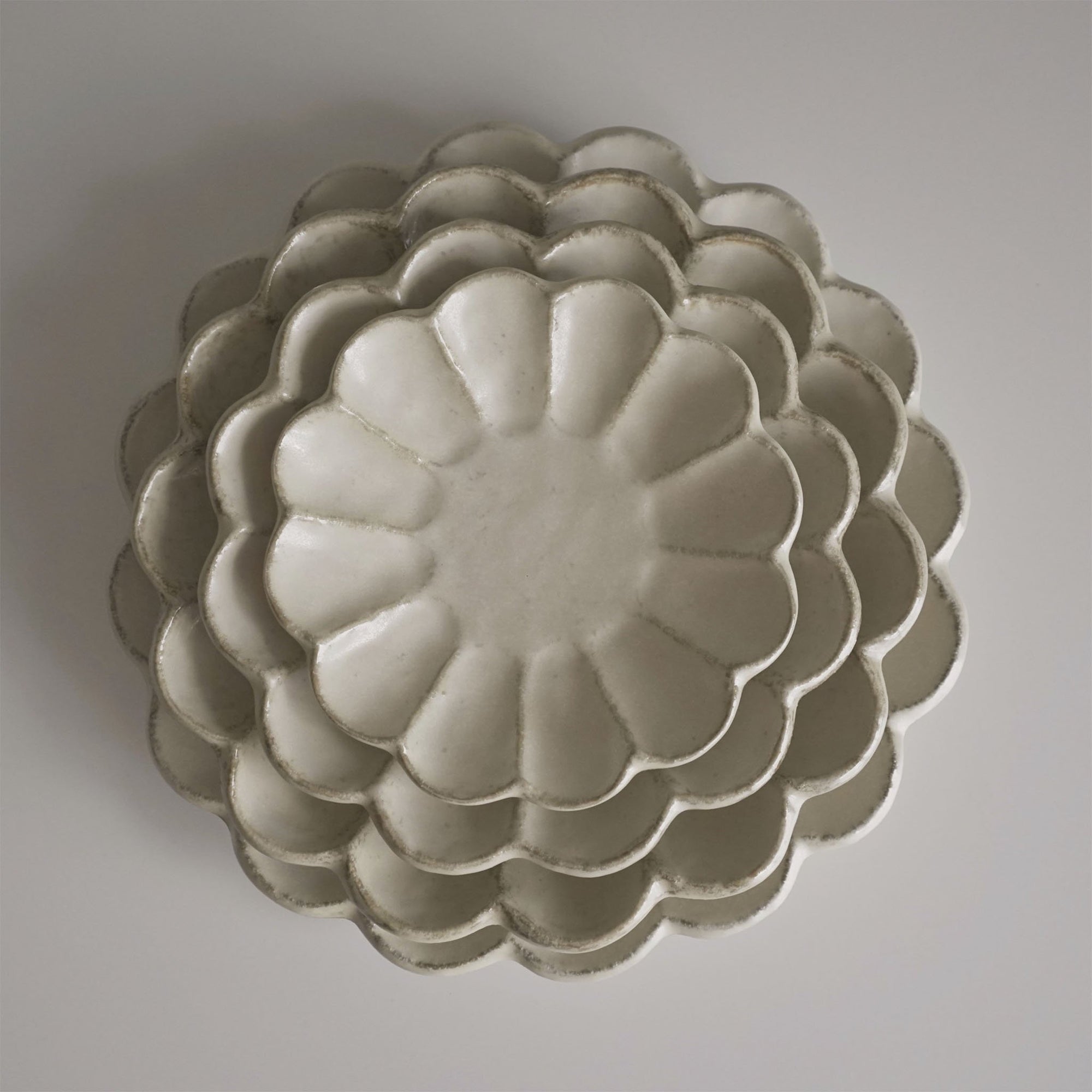 Stacked Rinka porcelain plates from Japan, showcasing exquisite craftsmanship and elegant design.