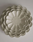 Stacked Rinka porcelain plates from Japan, showcasing exquisite craftsmanship and elegant design.