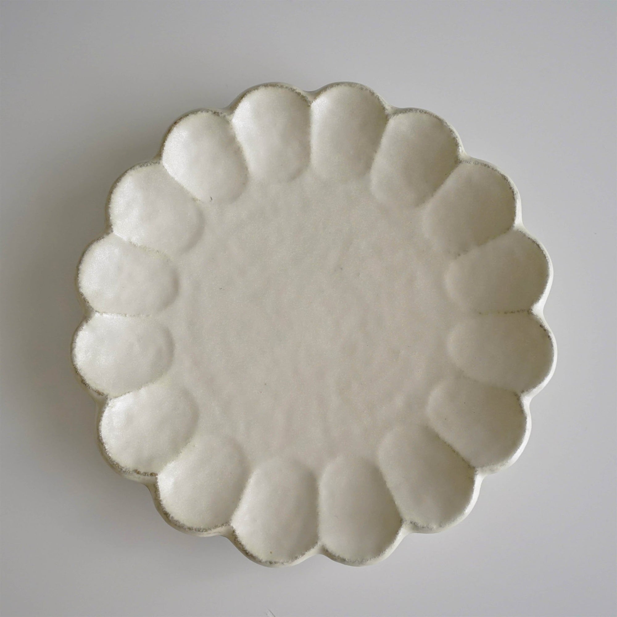 Elegant Rinka Plate 24cm in porcelain, handcrafted in Japan, featuring a timeless design with scalloped edges. Microwave and dishwasher safe.