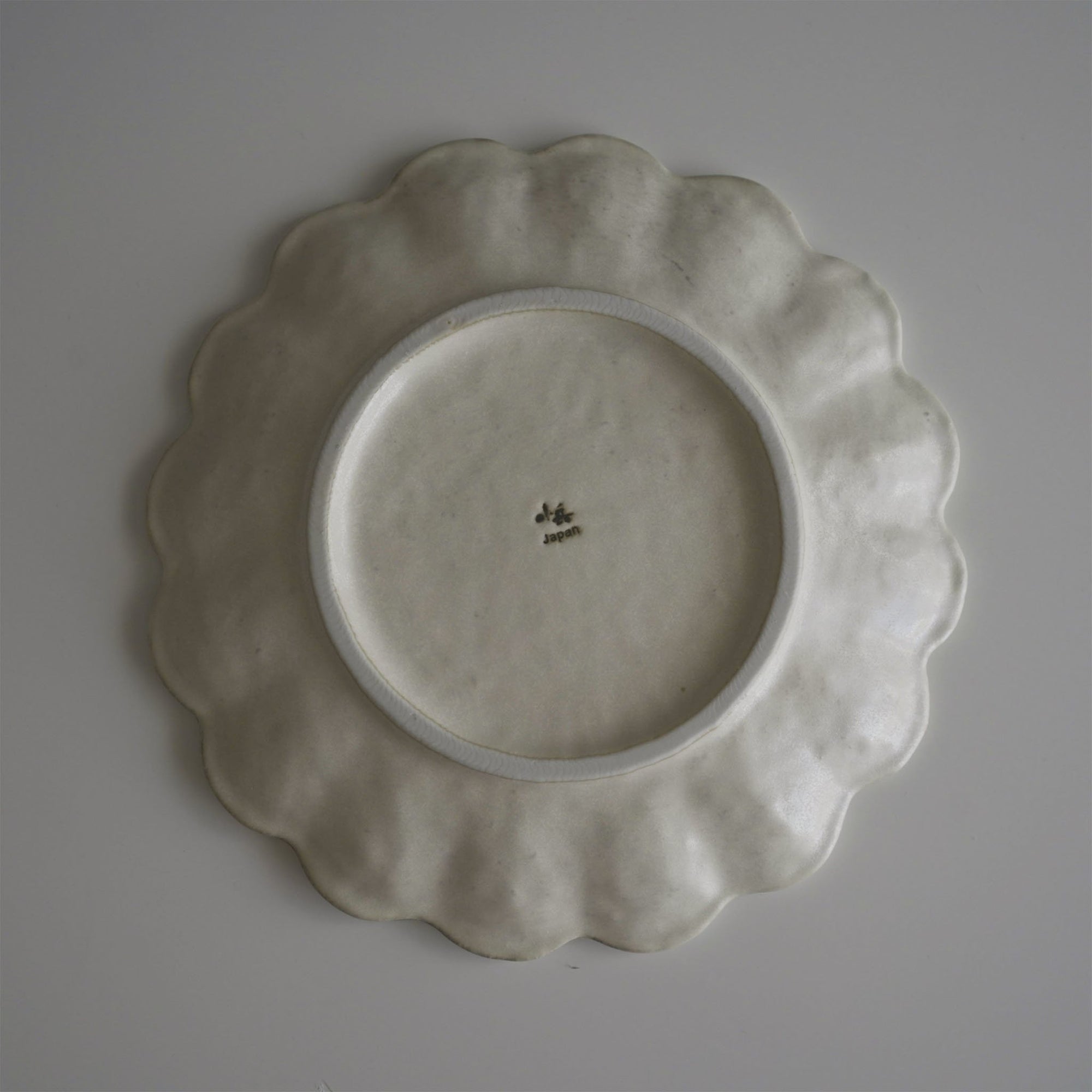 "Rinka Plate 24cm base view, handcrafted porcelain with elegant scalloped design, made in Japan, microwave and dishwasher safe"
