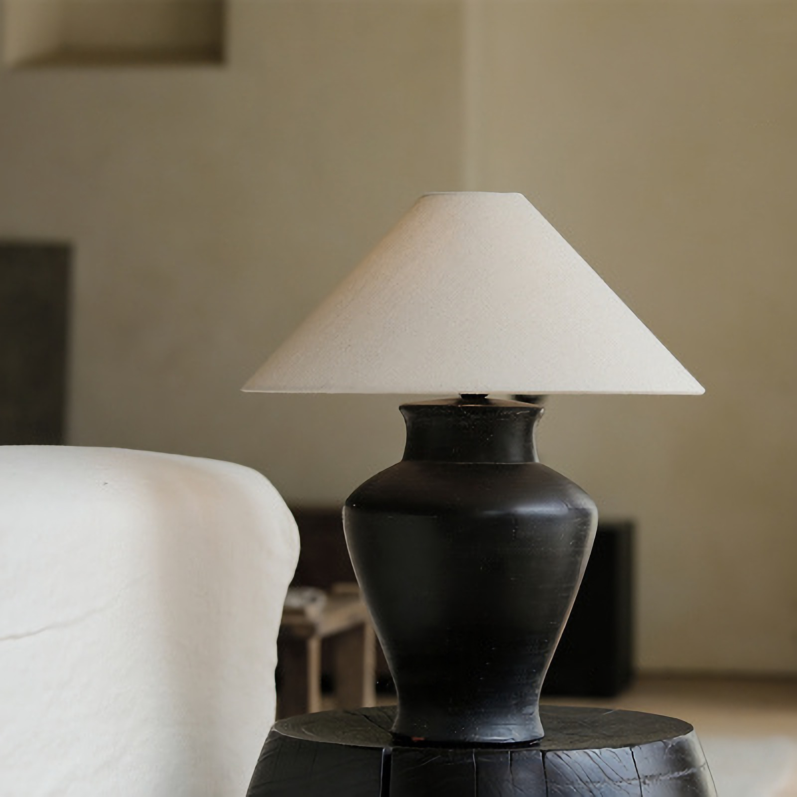 Short Neck Table Lamp with clay base and linen shade on a side table, offering warm, adjustable light for cozy home decor ambiance.