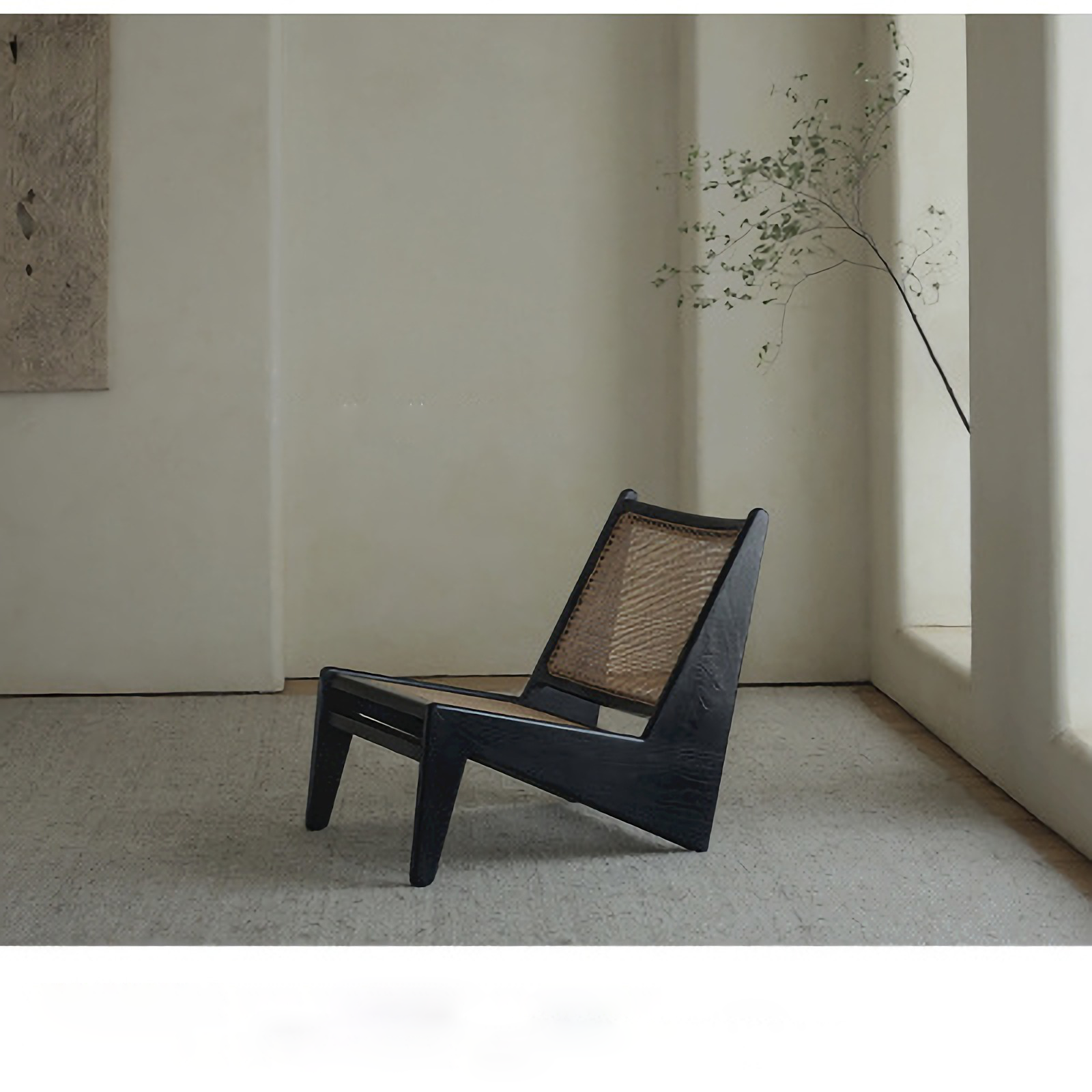 Black rattan Kangaroo Chair with solid wood frame in a minimalist room setting, showcasing unique "Z" shape design and slanted legs.