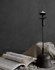 Antique-style Aimu floor candle holder beside an open book, adding a vintage touch to home decor.