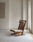 Nakajima George reclining chair made of teak and rattan in a minimalist room, showcasing handcrafted elegance and natural materials.