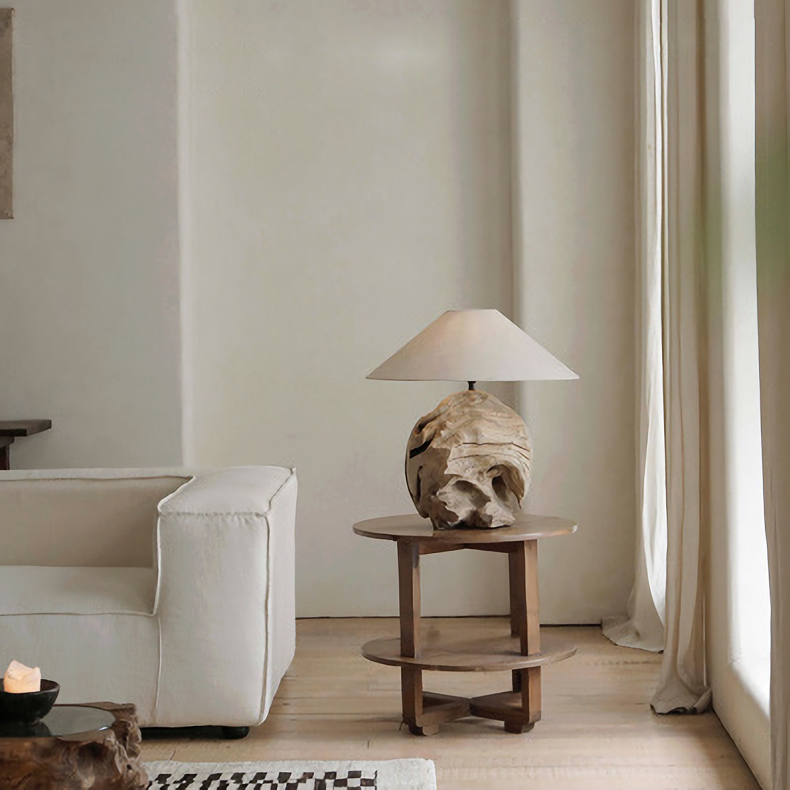 Stylish carved table lamp made from recycled wood with unique patterns, on a wooden side table in a cozy, minimalist living room setting.