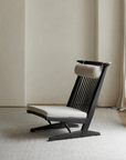 Nakajima George Reclining Chair with teak wood and rattan weaving, inspired by carvings, offers a romantic vibe in a minimalist setting.