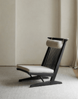 Nakajima George Reclining Chair with teak wood and rattan weaving, inspired by carvings, offers a romantic vibe in a minimalist setting.