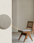 Solid wood rattan dining chair with gray cushion, showcasing hand-woven teak frame and intricate rattan backrest design.