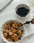Elegant bowls filled with mini pancakes and blueberries, showcasing fine Japanese porcelain craftsmanship.