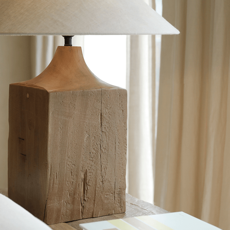 Old wood table lamp with hand-polished base and linen lampshade, enhancing a natural, warm atmosphere with adjustable brightness.