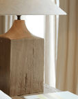 Old wood table lamp with hand-polished base and linen lampshade, enhancing a natural, warm atmosphere with adjustable brightness.