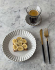 Elegant Marumitsu Barbarie plate with banana toast and cup of coffee on marble table setting