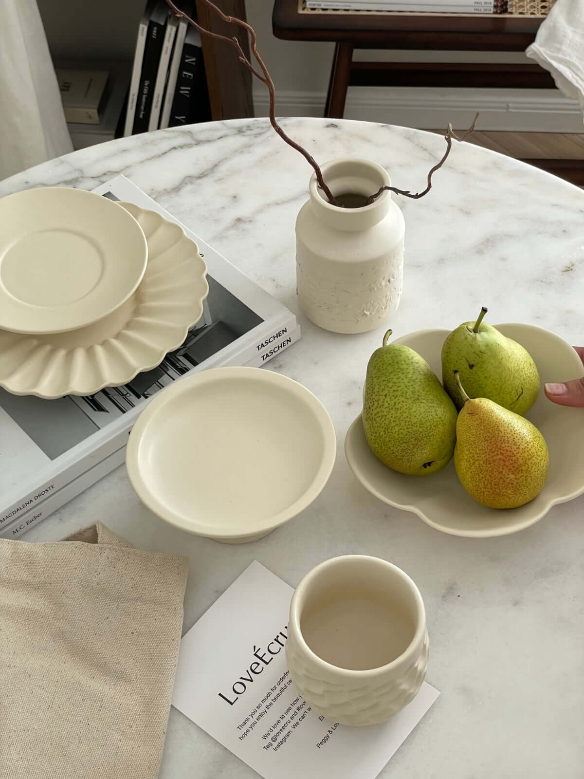 Yoshida Pottery Collection on marble table with plates, bowl, cup, vase, and pears in a tray, showcasing elegant ceramic craftsmanship.