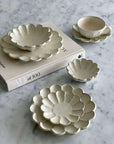 Elegant Rinka porcelain dishware set with flower petal designs on a marble surface, showcasing Japanese craftsmanship.