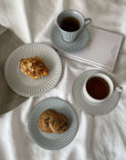 Storia coffee cup & saucer set with cookies and pastry, featuring European-inspired design and intricate detailing on porcelain.