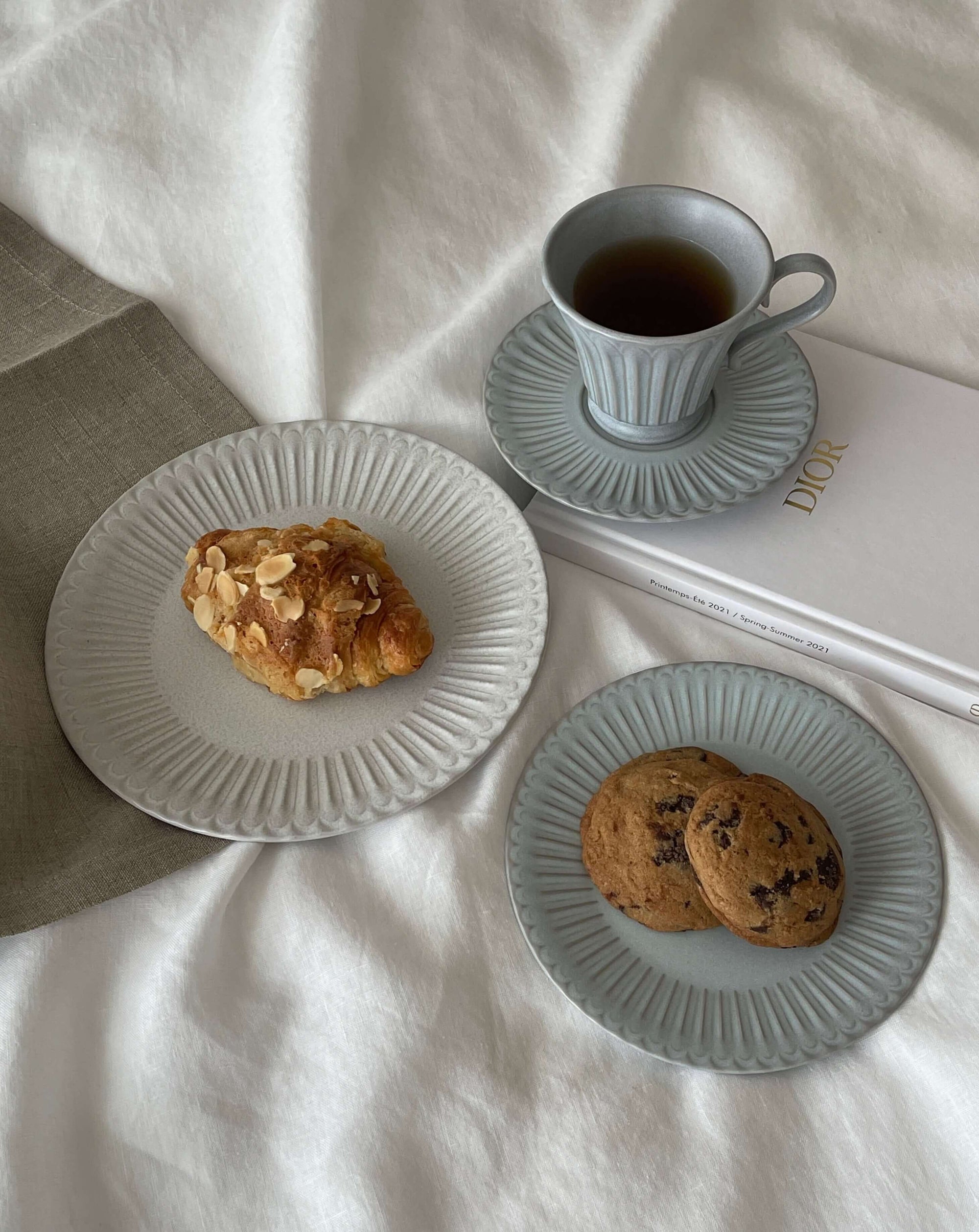 Storia tall coffee cup with saucer, elegant porcelain tableware, featuring soft lacquer finish, paired with pastries and cookies.