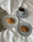 Storia tall coffee cup with saucer, elegant porcelain tableware, featuring soft lacquer finish, paired with pastries and cookies.