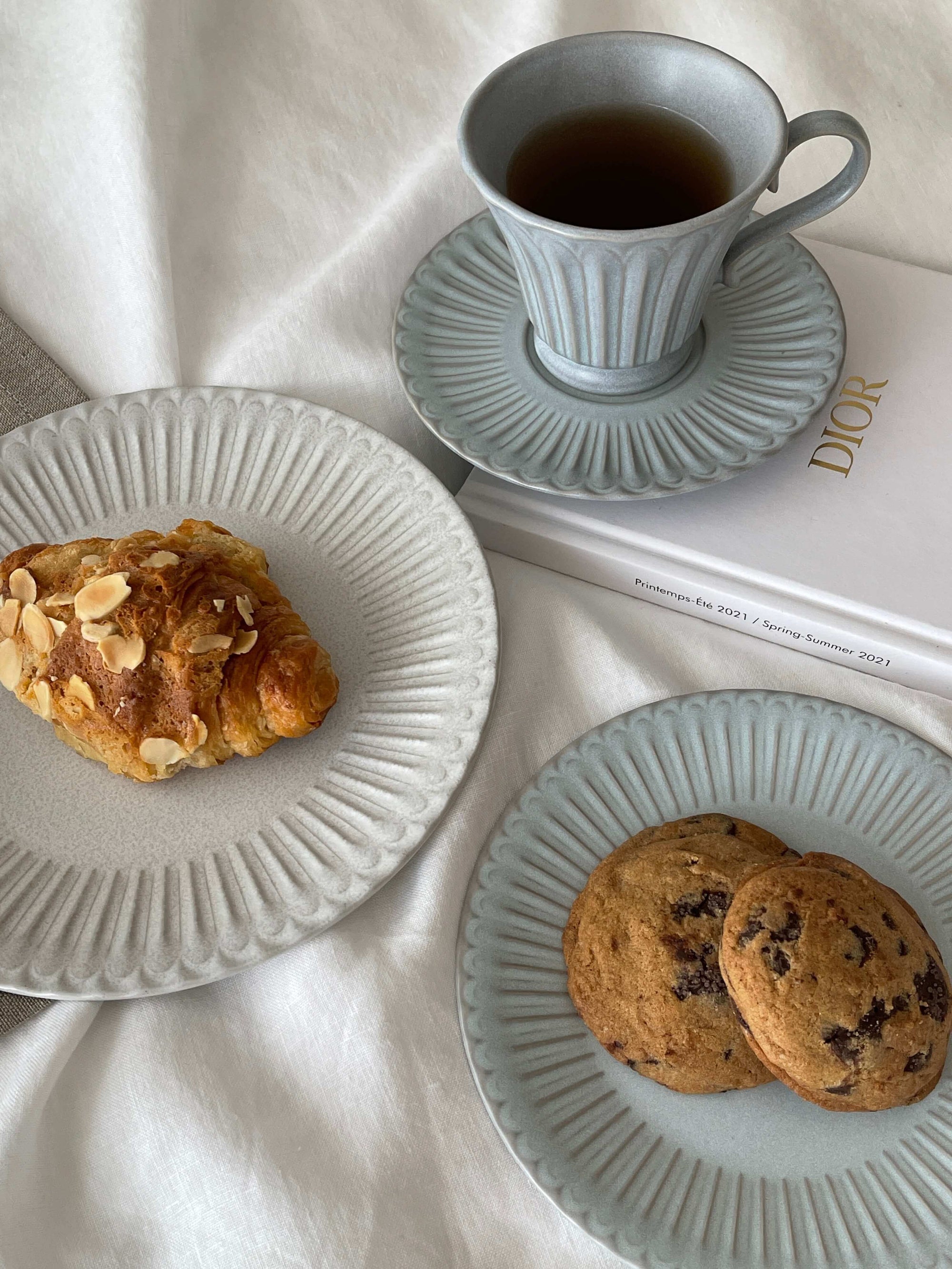 Storia Tall Coffee Cup & Saucer with pastries on elegant porcelain plates, evoking nostalgia and sophistication.