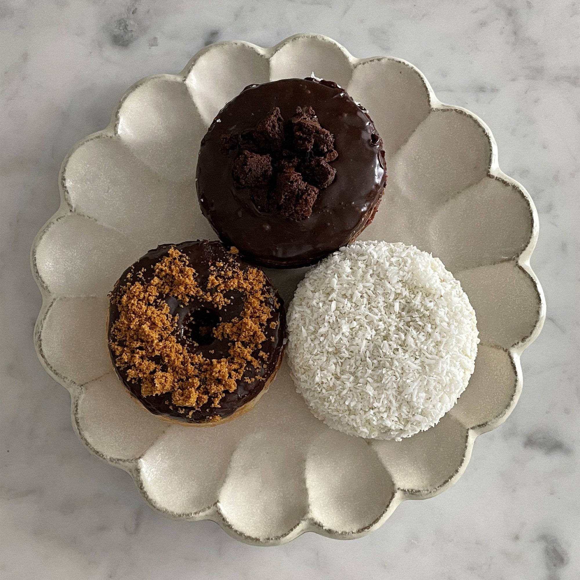 Rinka Plate 24cm with three assorted donuts on a marble surface, showcasing the elegant, handcrafted Japanese porcelain design.