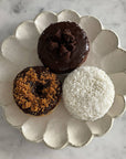 Rinka Plate 24cm with three assorted donuts on a marble surface, showcasing the elegant, handcrafted Japanese porcelain design.