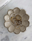 Rinka Bowl 10cm by Kaneko Kohyo with jewelry, showcasing handcrafted porcelain flower design on a marble surface.