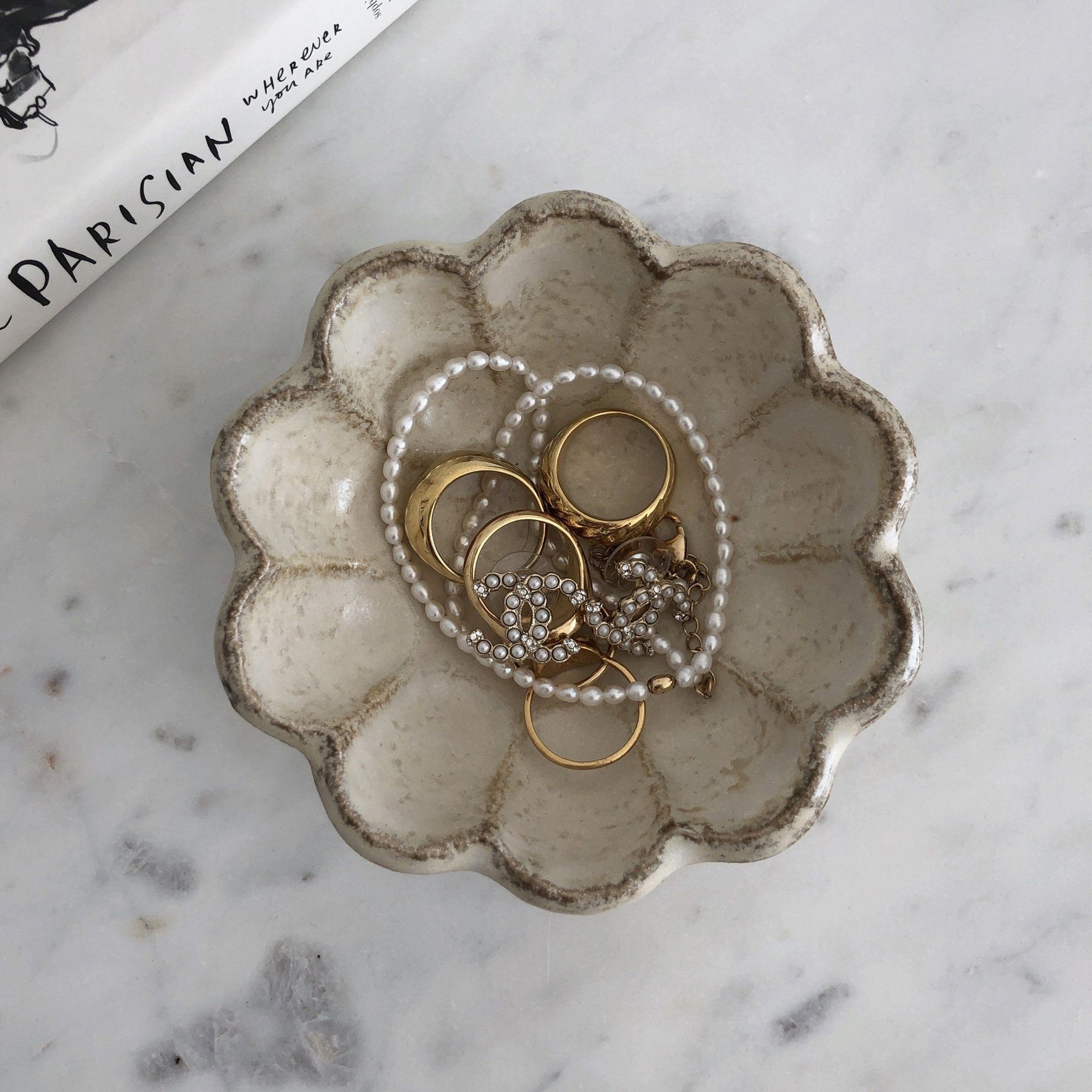 Rinka Bowl 10cm by Kaneko Kohyo with jewelry, showcasing handcrafted porcelain flower design on a marble surface.