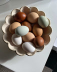 Assorted eggs in a flower-shaped Rinka Bowl made of porcelain, showcasing the delicate craftsmanship of the Kaneko Kohyo collection.