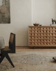Medieval sideboard cabinet with intricate design in a rustic dining room setting, featuring a decorative sculpture on top.