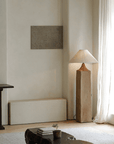Modern living room with a Stake Floor Lamp featuring linen shade and natural wood base, providing soft, cozy lighting near a large window.
