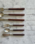 Elegant rosewood cutlery set including dessert fork, dessert spoon, dessert knife, cake fork, teaspoon, and butter knife on marble背景