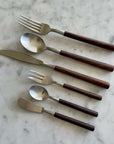 Elegant Rosewood cutlery set with unique natural wood grain handles on a marble surface, featuring forks, spoons, and knives.