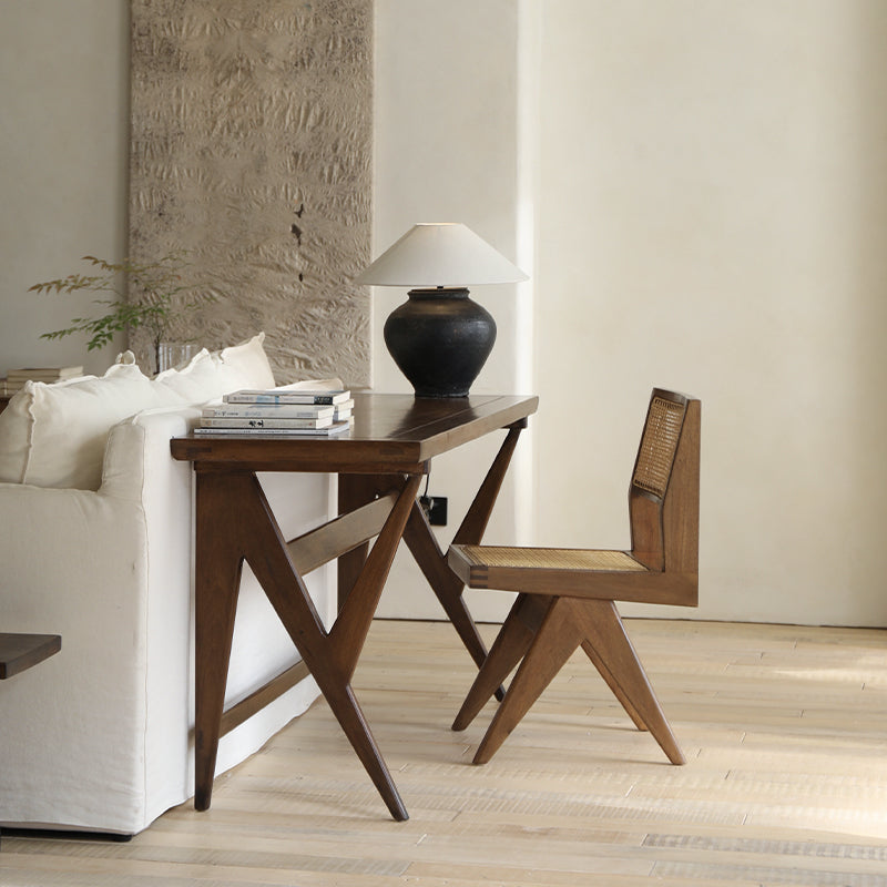 Hand-made wood-mounted dining chair with rattan weaving, set against a modern desk and sofa, enhancing a room's romantic vibe.