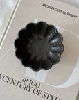 Black Rinka Bowl by Kaneko Kohyo on an Architectural Digest book, showcasing its unique handmade texture and design.