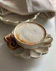 Rinka Soup Cup by Kaneko Kohyo with coffee on porcelain saucer, showcasing handcrafted flower shape design, perfect for table setting.