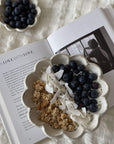 Rinka Bowl 16cm filled with granola, coconut flakes, and blueberries on an open book, showcasing Japan's Kaneko Kohyo craftsmanship.